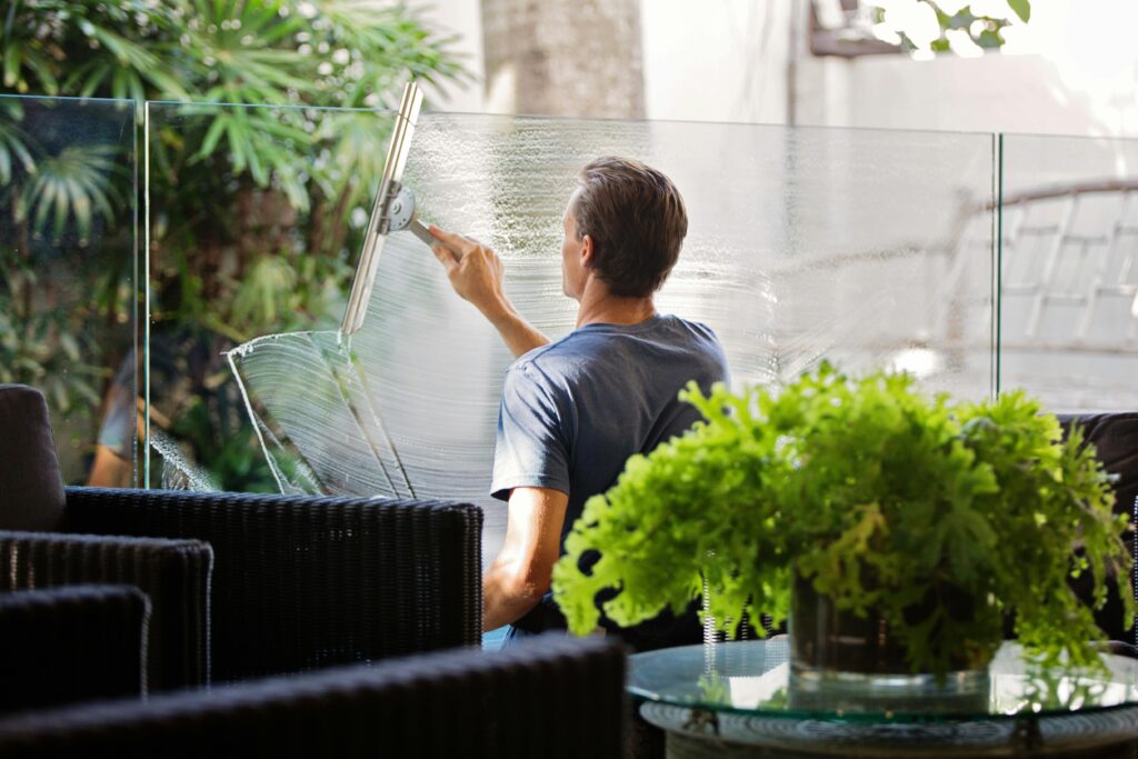 pexels-photo-713297-713297 Man in Gray Shirt Cleaning Clear Glass Wall Near Sofa